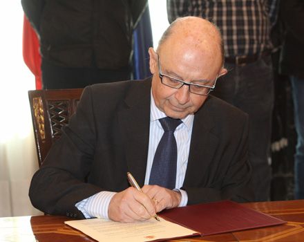 Cristóbal Montoro firma el acuerdo al que ha llegado el Gobierno con los sindicatos.