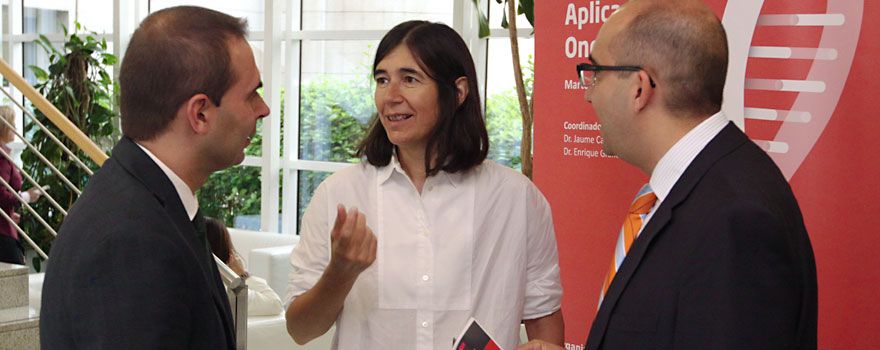 María Blasco, directora del CNIO, conversa con los coordinadores del Simposio, Jaume Capdevila (izquierda), del Centro Médico Teknon, y Enrique Grande, del Ramón y Cajal.
