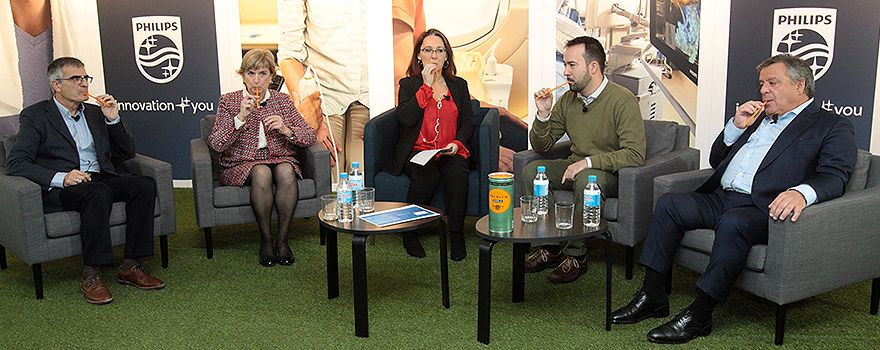 Los ponentes en la jornada de Philips y Separ explican cómo se siente un paciente con EPOC respirando a través de pajitas.