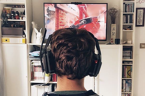 Un adolescente juega videojuegos en su cuarto. / Imagen de stock (Envato)